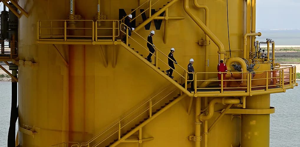 Inspection team descending a stairway on an offshore platform