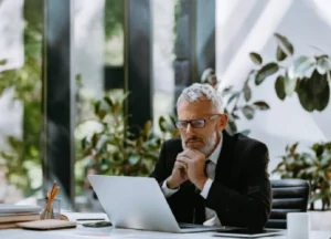 Senior executive reviewing performance and risk data with a focused expression in a modern office