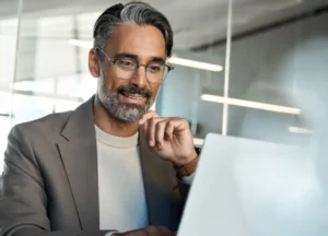 A senior executive reviews a strategic report on a tablet in a modern office. The image reflects executive oversight, risk evaluation, and high-level decision making beyond marketing operations.